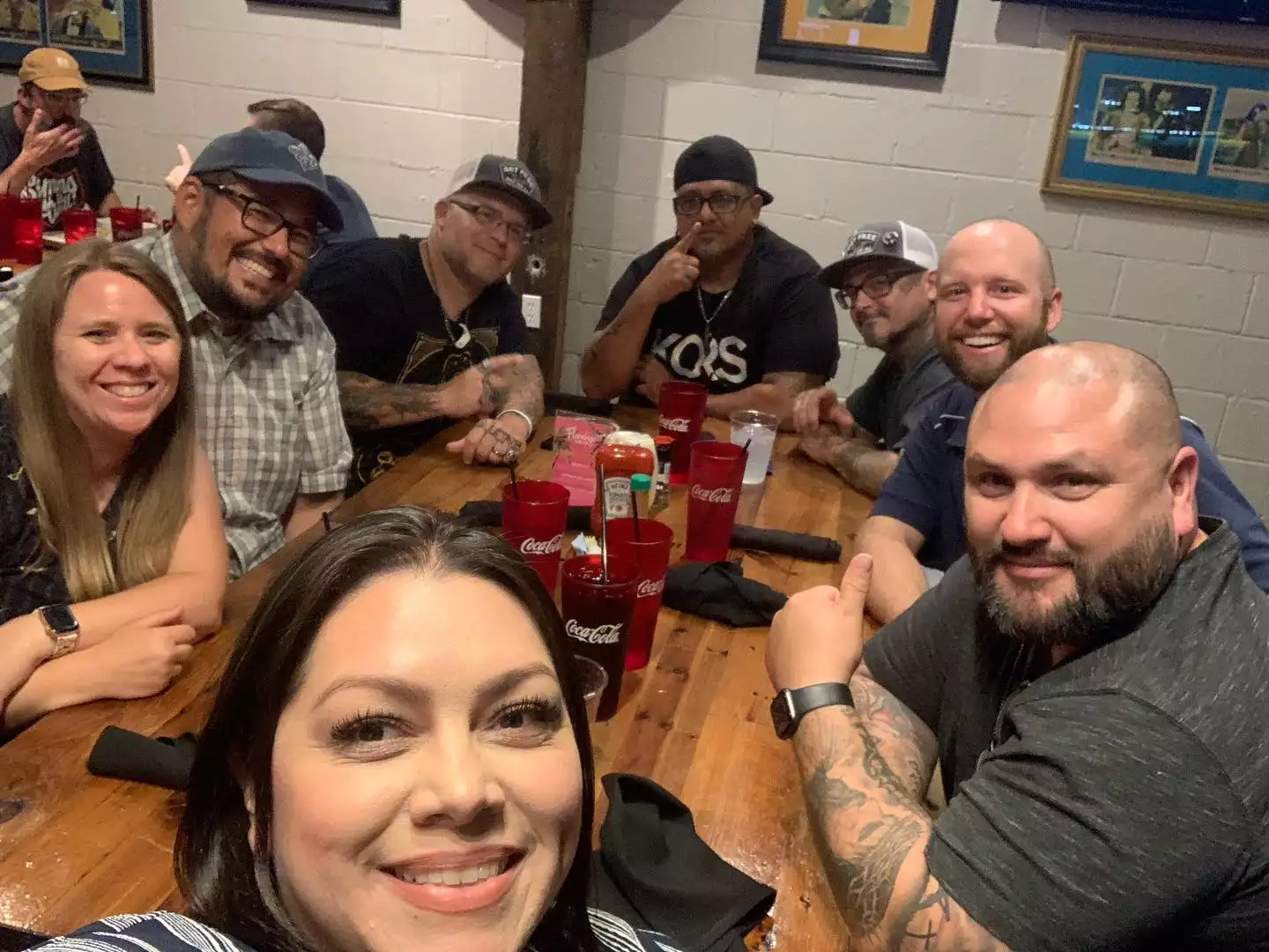 A group of church leaders posing for a photo around a long table at a restaurant meal